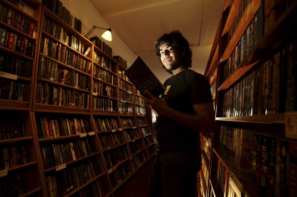 Aaron Swartz standing amongst books in a library